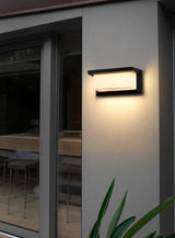 Slim outdoor wall light mounted beside wide glass patio doors