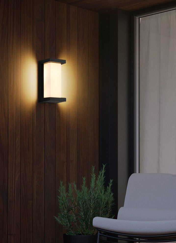 Vertical outdoor light glowing against dark timber cladding at night