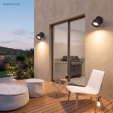 Small round adjustable spot light mounted on a red brick wall