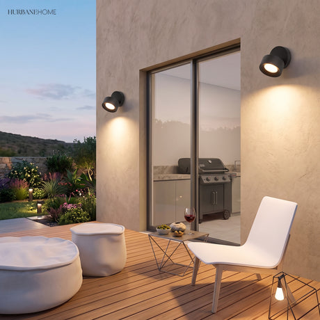 Small round adjustable spot light mounted on a red brick wall