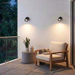 Round wall spot angled downward beside outdoor lounge seating