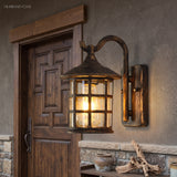 Seeded glass lantern lit warm beside a carved timber front door