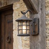Lantern wall light on a sandstone wall beside a studded door