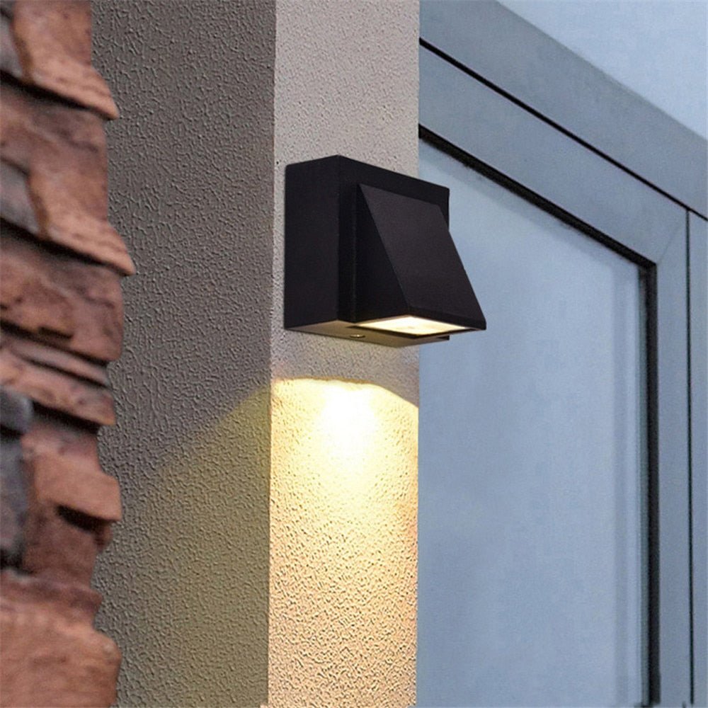 Outdoor wedge wall light throwing a warm beam down a rendered wall