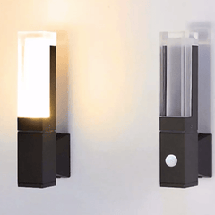 Two prism wall sconces lit on a wall with the sensor version in front