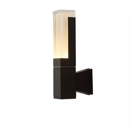 Single head prism wall sconce lit warmly on a pale wall