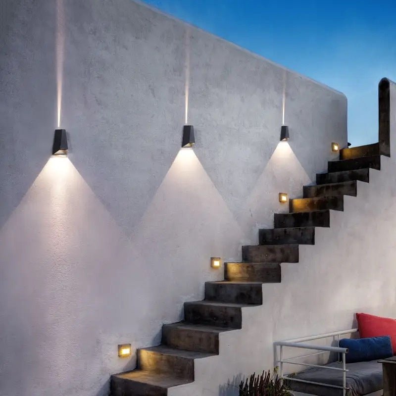 Row of wedge sconces lighting a rendered garden staircase at twilight
