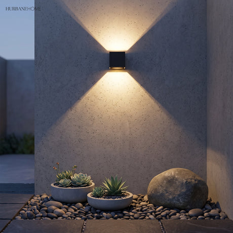 Black cube sconce throwing beams up and down a concrete wall