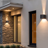 Cube sconce lighting a timber clad wall beside a doorway