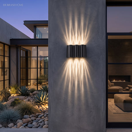 Rippled black wall sconce throwing light up and down a concrete wall