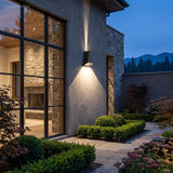 Wedge sconce lighting a rendered wall next to a tall window at night