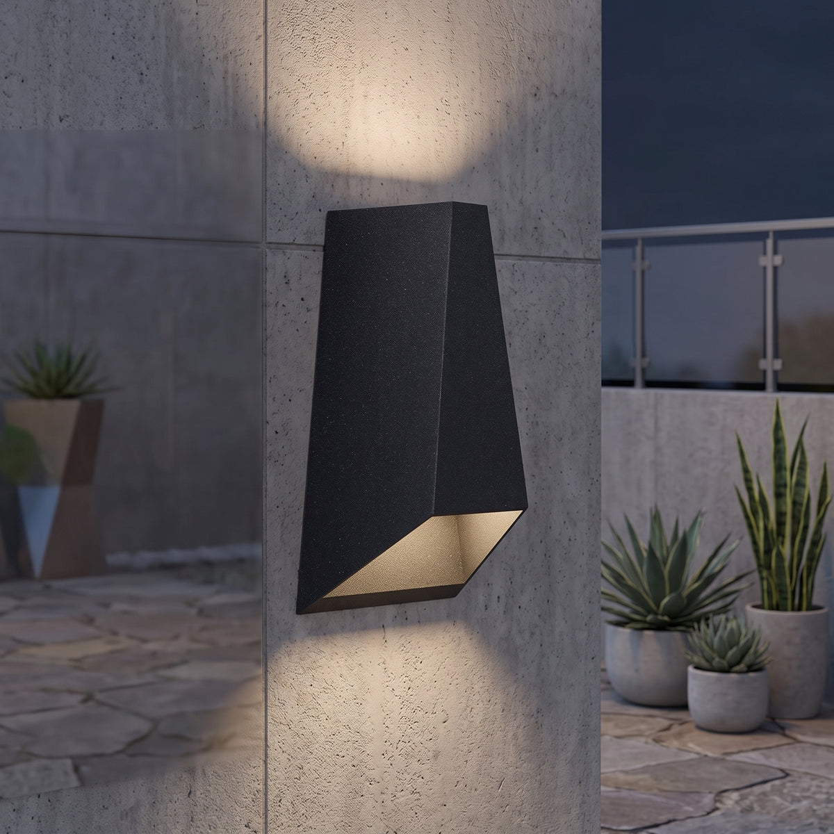 Black wedge outdoor wall sconce lighting a concrete wall above and below