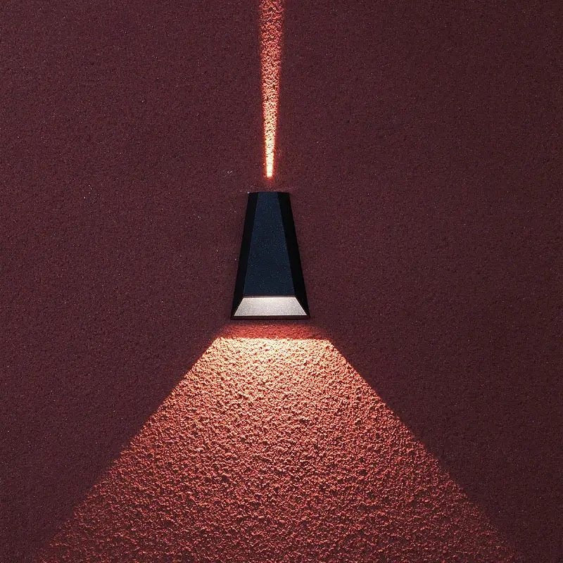 Close view of the sconce throwing light onto a deep red wall