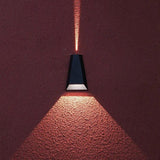Close view of the sconce throwing light onto a deep red wall