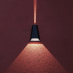 Close view of the sconce throwing light onto a deep red wall