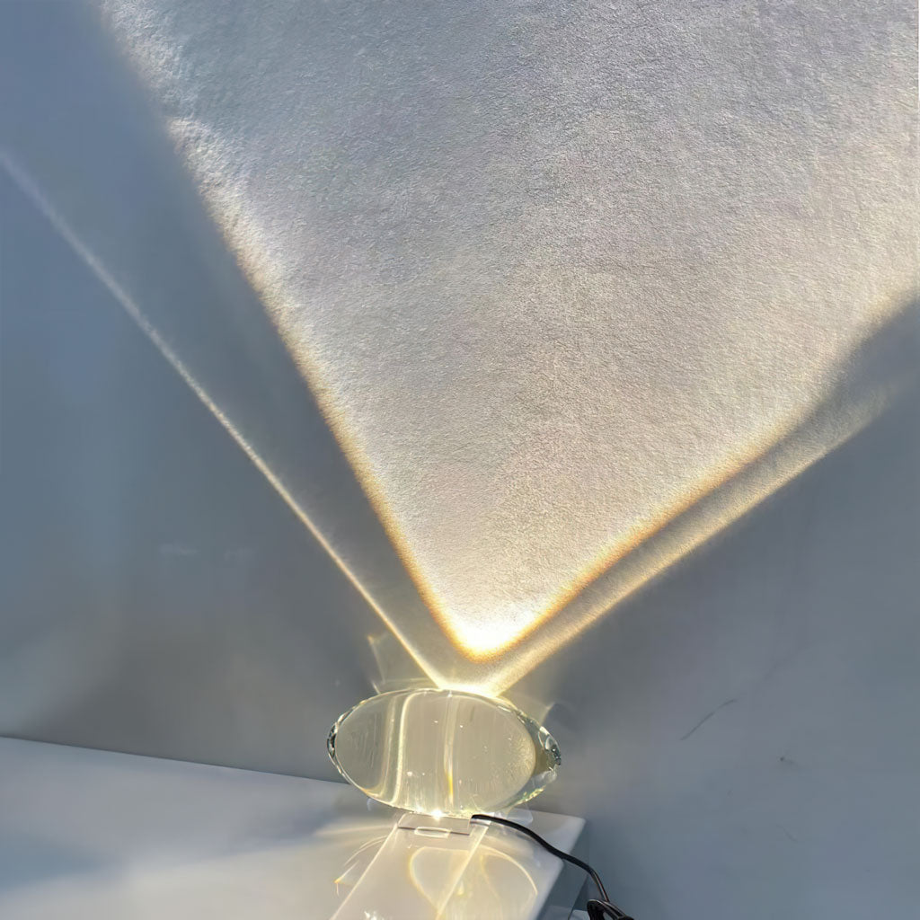 Oval glass lamp projecting a soft sunset oval on a wall