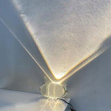 Oval glass lamp projecting a soft sunset oval on a wall
