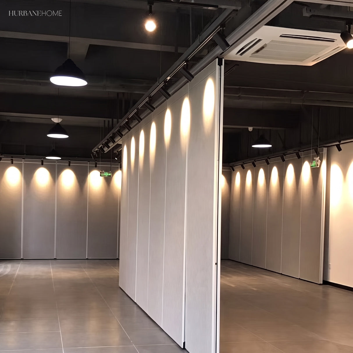 Black spotlights lighting a partition wall in a modern showroom