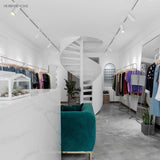White track spotlights lighting a bright minimalist clothing boutique