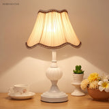 White base table lamp with gathered fabric shade and succulent