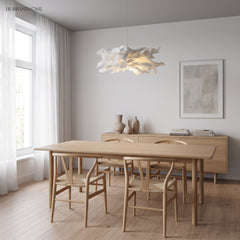 White paper pendant light hanging above a pale oak dining table by a window