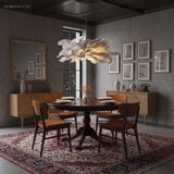 Paper pendant light over a dark dining room table with a patterned rug