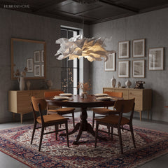 Paper pendant light over a dark dining room table with a patterned rug