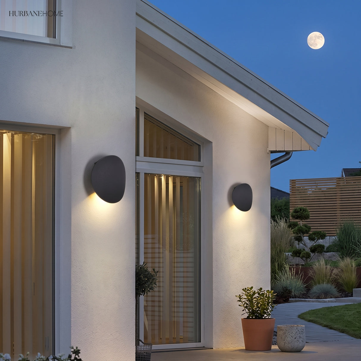 Pebble outdoor wall lights flanking a house entrance at dusk