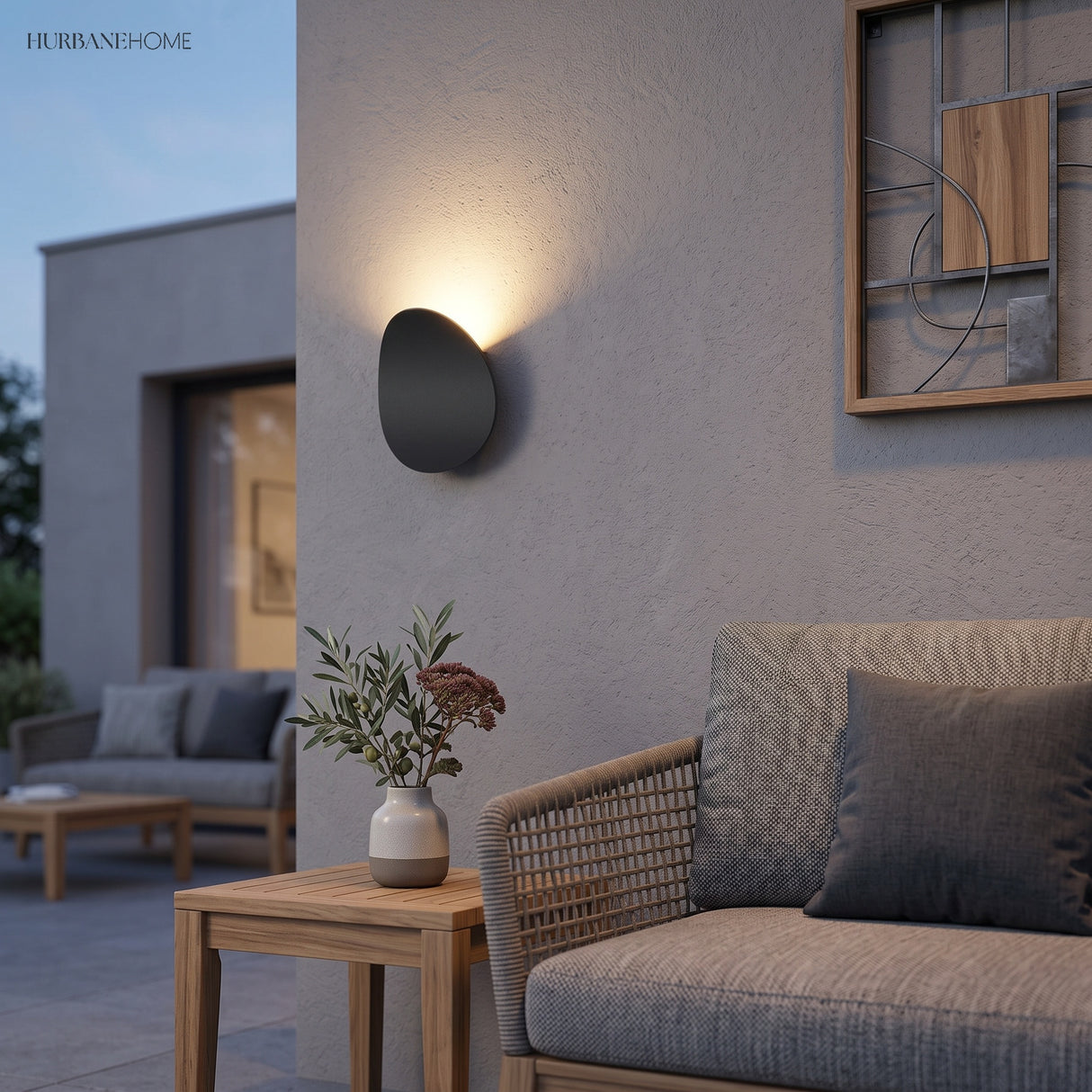 Pebble outdoor wall light above an outdoor lounge setting