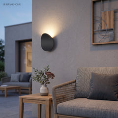 Pebble outdoor wall light above an outdoor lounge setting