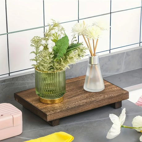 Pedestal tray stand holding soap and candle on bathroom counter