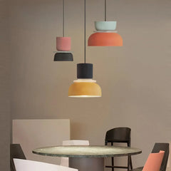 Three colorful pendant lights above a brown dining table