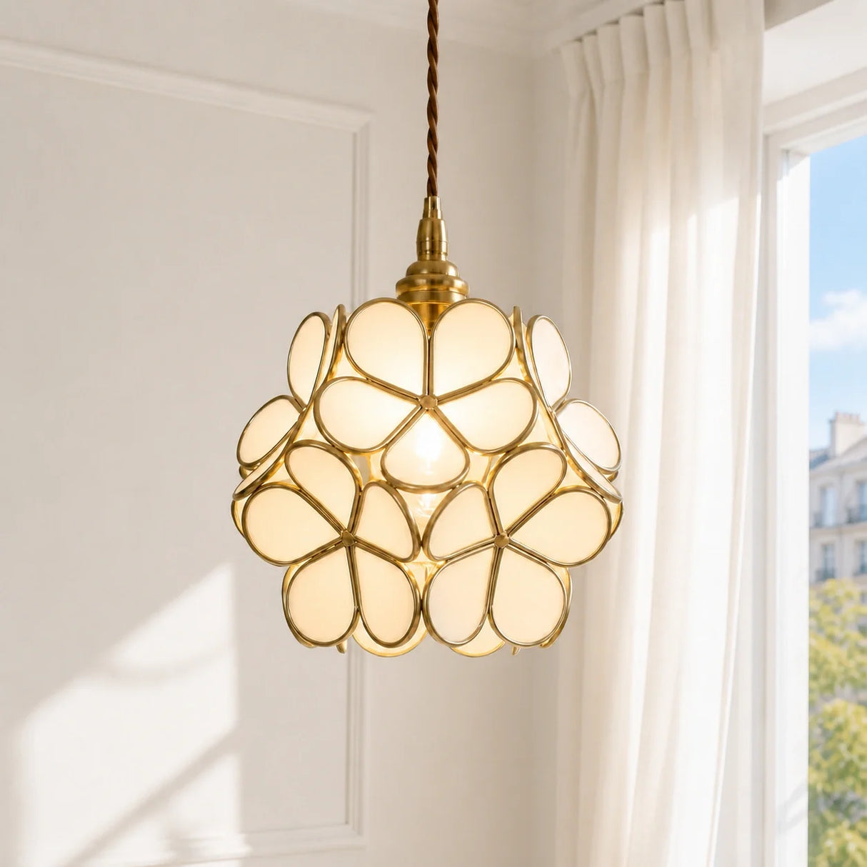 Detail of brass frame holding overlapping engraved glass petals on the pendant