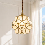 Detail of brass frame holding overlapping engraved glass petals on the pendant