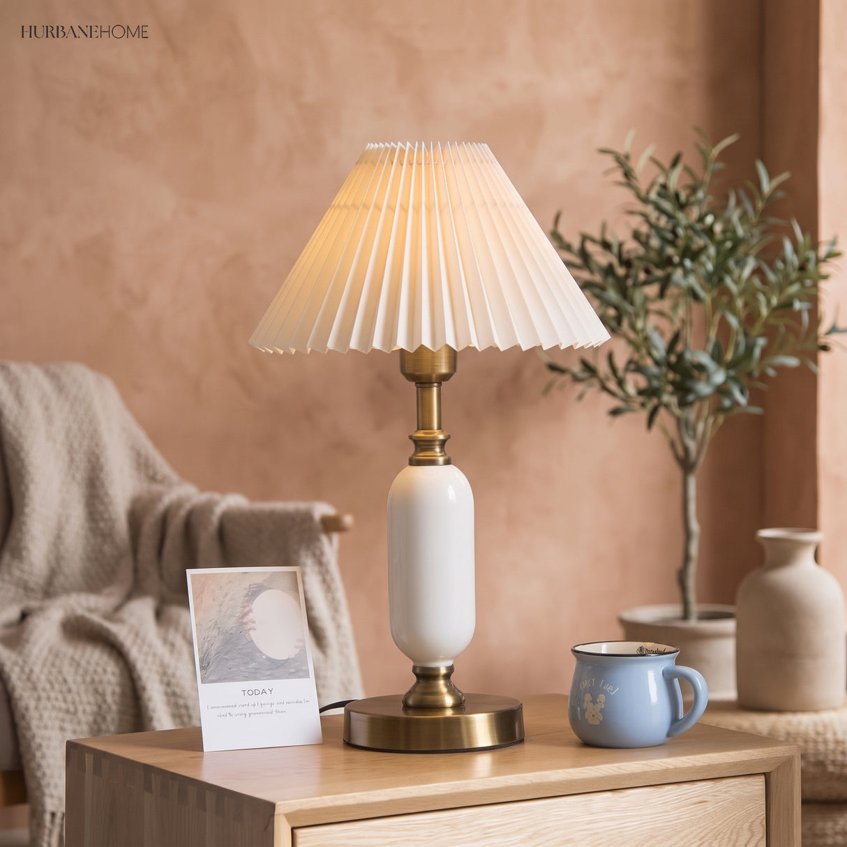 Pleated bedside table lamp glowing warmly on a side table by a chair