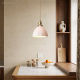 Pleated ceramic pendant with brass holder above a marble kitchen corner