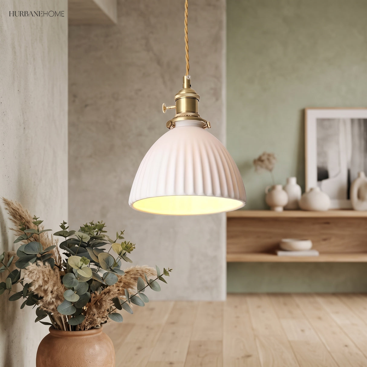 White pleated pendant on twisted cord beside a shelf of pottery