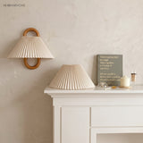 Pleated fabric wall sconce adding warm light beside furniture