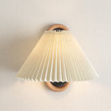 Pleated fabric shade wall sconce with wooden ring bracket, studio product photo