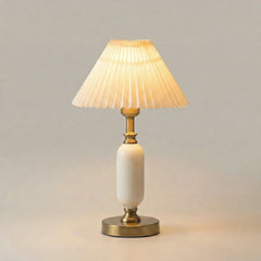 White pleated table lamp with brass column base, front view