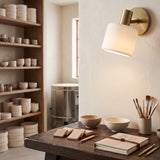 Ivory porcelain sconce above a workbench of stacked ceramic bowls