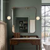 Round porcelain wall lights flanking a mirror above a vintage washstand
