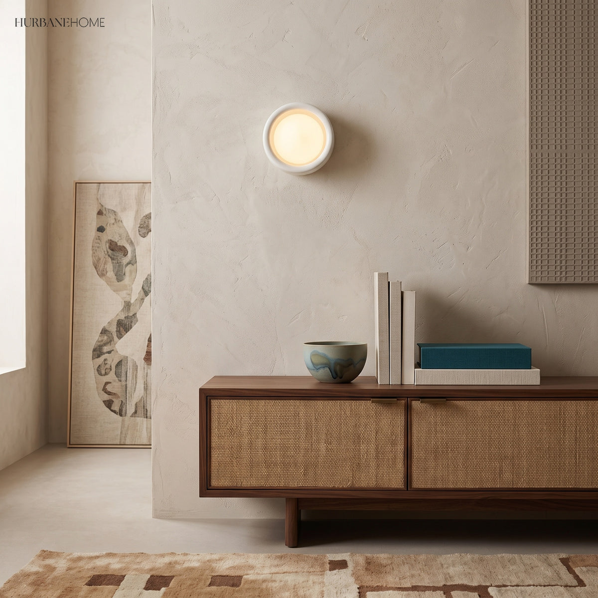 Flush porcelain disc wall light above a cane fronted sideboard