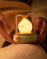Hand lifting the lit night light from the top of a soft cream blanket