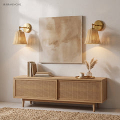 Two brass rattan sconces flanking abstract art above a cane sideboard