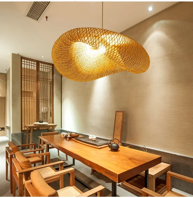 Rattan pendant lit gold above a console with a vase of branches