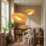 Three bamboo pendants at staggered heights beside a bookshelf and sofa