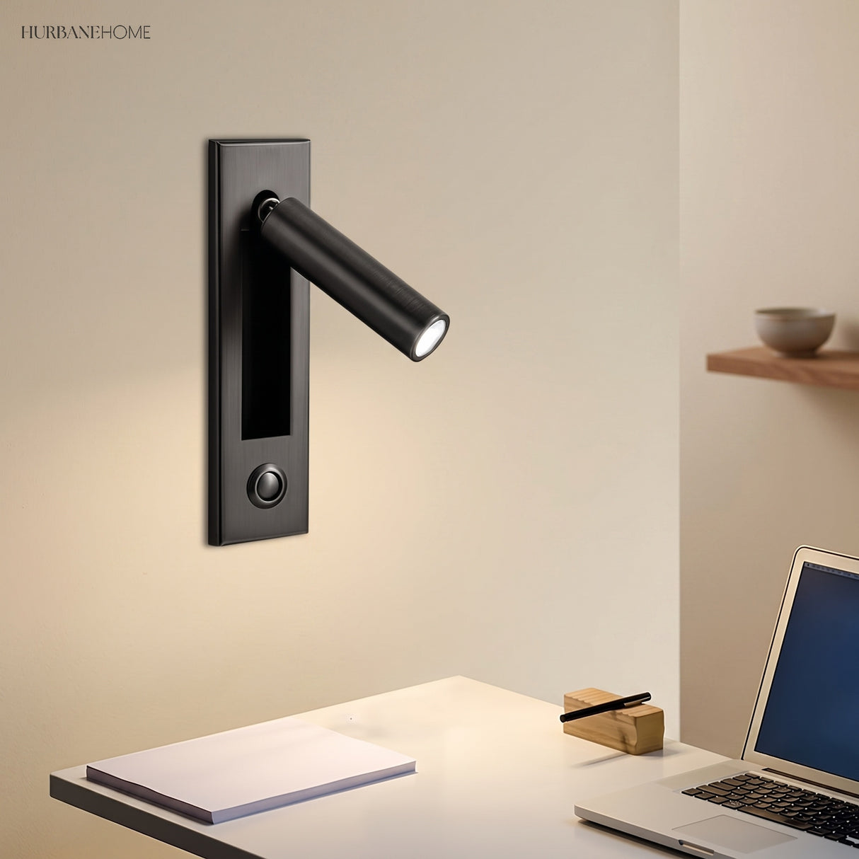 Reading wall sconce above a desk with a laptop and notebook