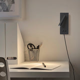 Plug-in reading wall light casting a focused pool of light