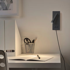 Plug-in reading wall light casting a focused pool of light